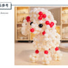 A white, fluffy, dog-shaped figurine made of pearl beads is displayed on a wooden surface.