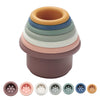 A stack of silicone cups in various shades of beige, green, and brown for toddlers.