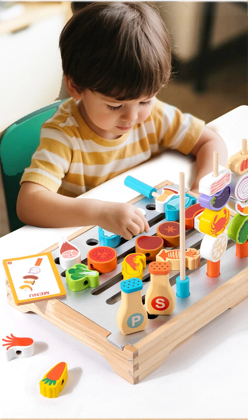 A young child is playing with a wooden BBQ playset featuring matching game pieces and food items.
