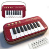A red mini piano keyboard for kids with a white key layout and a separate numbered practice sheet.