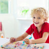 A smiling toddler is playing with a wooden magnetic color sorting maze puzzle board.