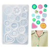 A clear silicone mold tray containing various shapes for casting buttons and jewelry components.