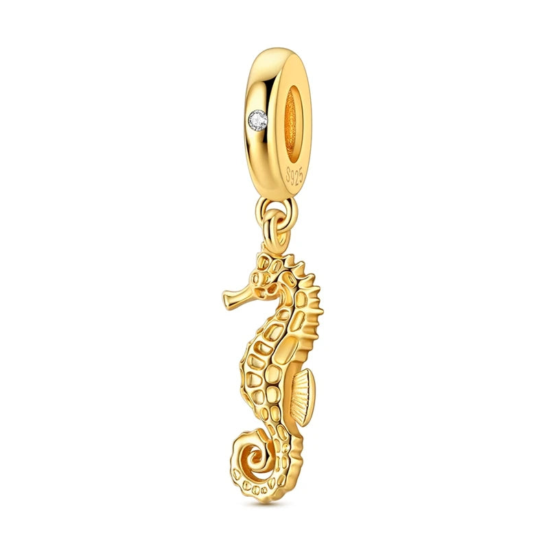 Gold-toned charm pendant set featuring a starfish, sea turtle, and whale shark.