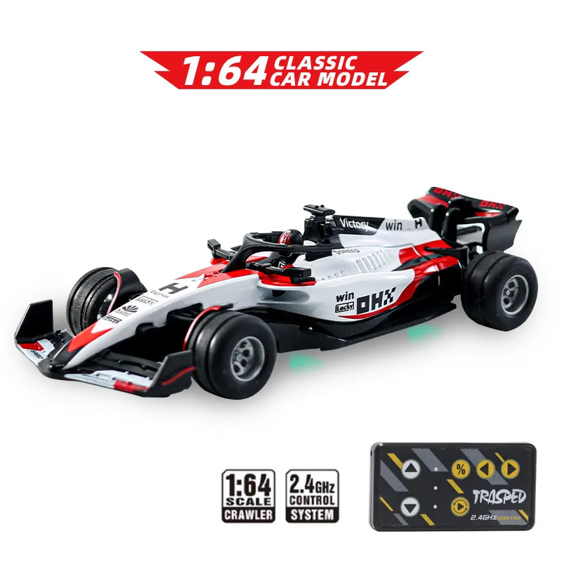 A white and red 1:64 classic car model racing on a surface, with a remote control system box nearby.