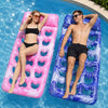 Two adults relaxing on inflatable pool floats, one pink and one blue.