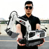 A man holds a white RC excavator engineering truck with an attached hydraulic arm and bucket.