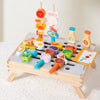 A wooden BBQ playset with matching game featuring various food items and tools for toddlers.