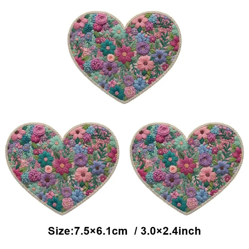 A heart-shaped floral embroidery patch featuring pink, purple, and green flowers.