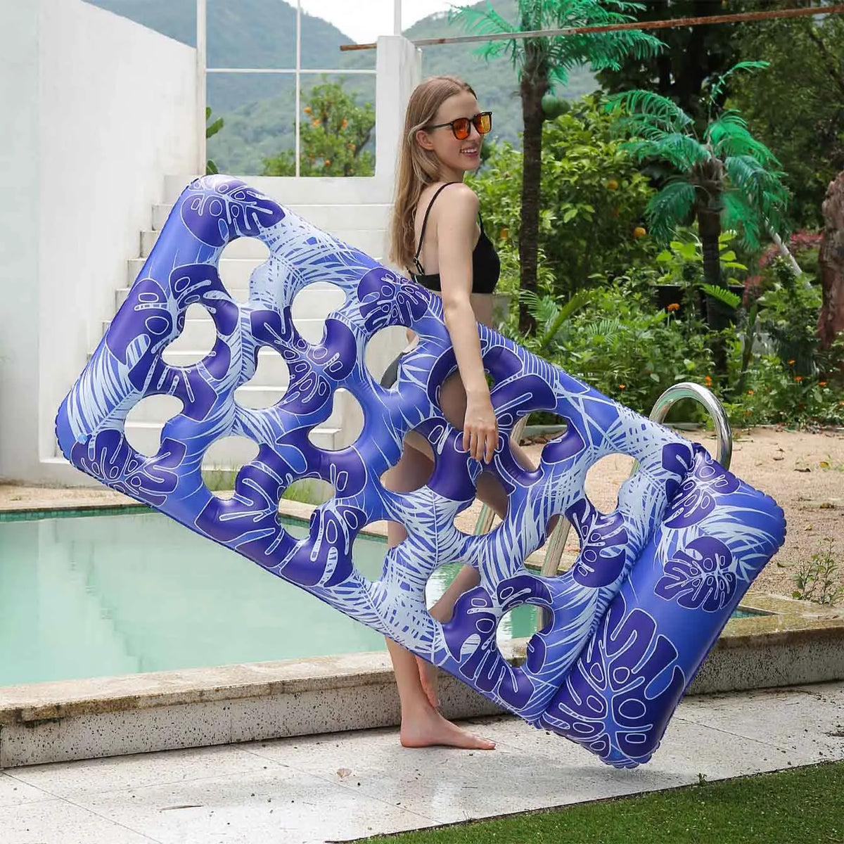 A purple inflatable pool float with a headrest is shown next to a woman by a swimming pool.