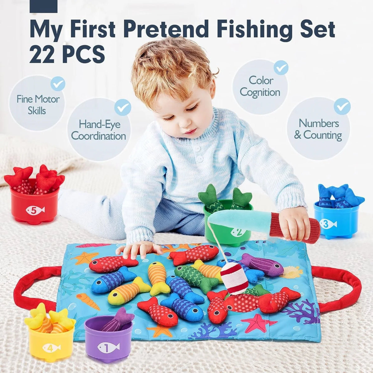 A toddler is playing with a pretend fishing set featuring 22 pieces including fish, cups, and counting items on a blue mat.