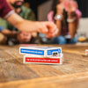 Une table en bois présentant plusieurs boîtes de cartes à jouer de la société United States Playing Card Company et des perso