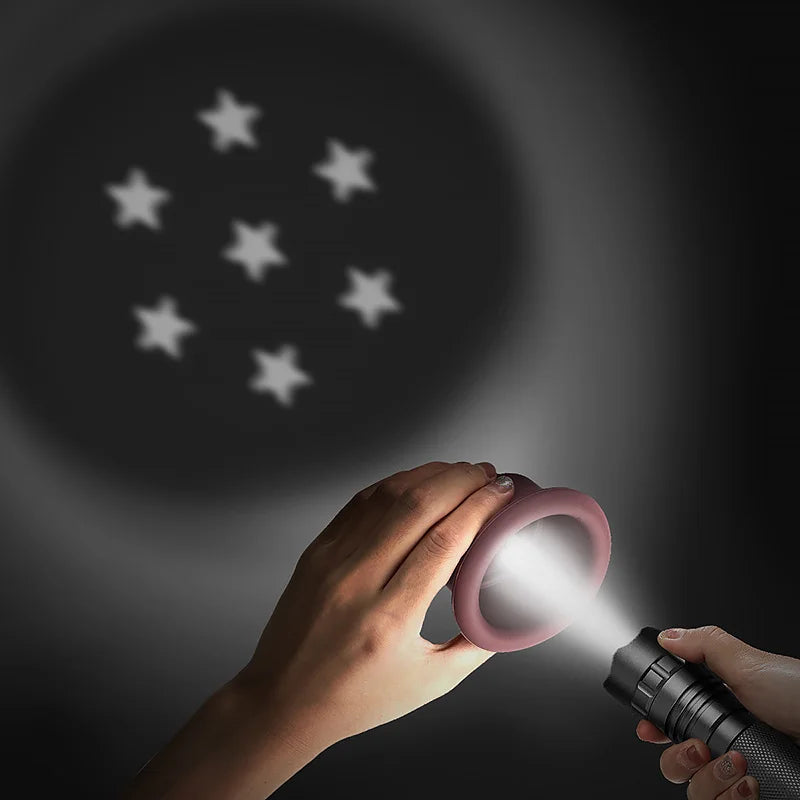 A hand holds a silicone stacking cup, illuminating a dark background with stars.