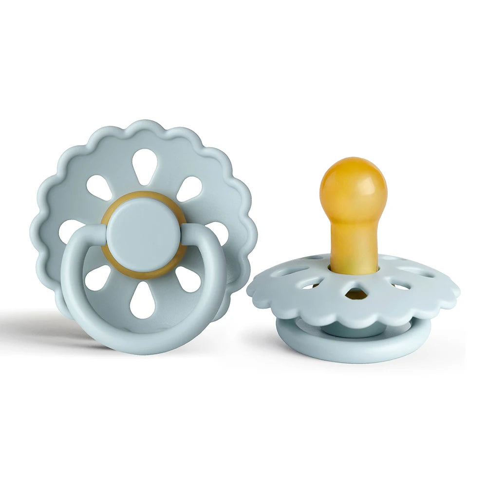 A light blue natural latex baby pacifier with a yellow nipple and a decorative flower-like silicone ring.