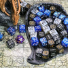 A collection of 63 dice in various colors and patterns is displayed in a dark bowl on a stone surface.
