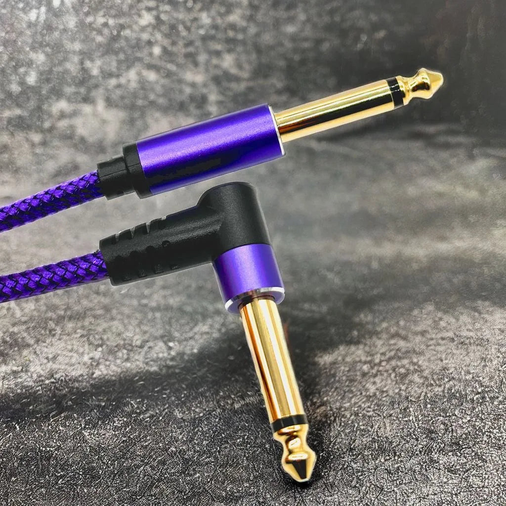A purple and black instrument cable with a gold connector is shown against a dark gray background.