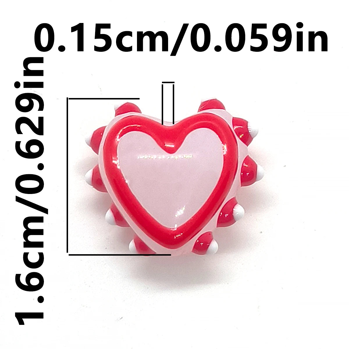 A small, heart-shaped glass bead with red and white accents for jewelry making.