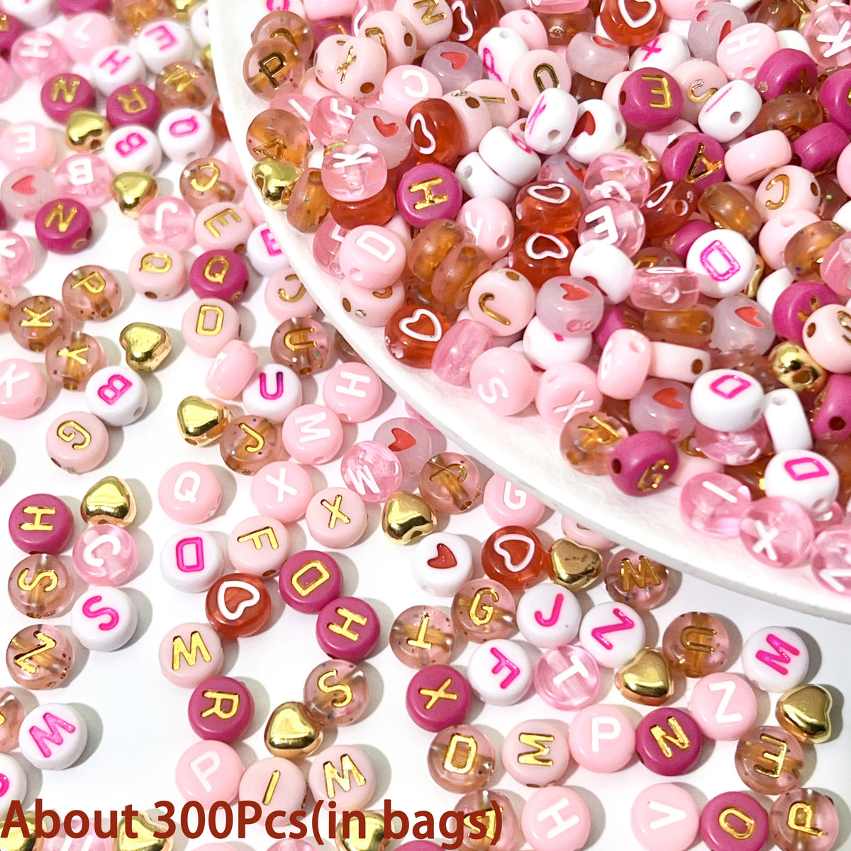 Assortment of pink, red, and white acrylic beads with gold accents for jewelry making