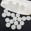 A translucent white plastic tray holds a pack of round, clear glass beads for jewelry making.