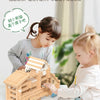 A child is building a wooden log cabin kit with small wooden pieces and animals.