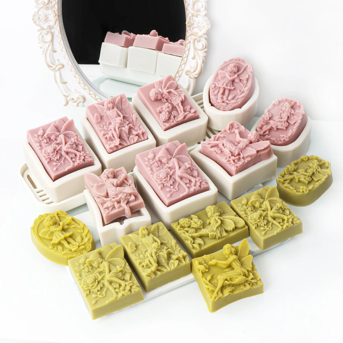 A collection of silicone soap molds featuring pink and green floral designs, including rose and butterfly patterns.