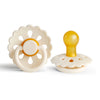 A white natural latex baby pacifier with a yellow silicone top and a flower-like design.
