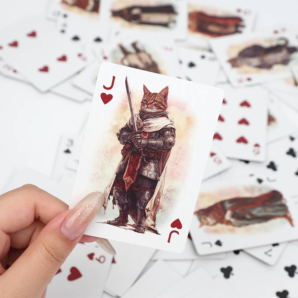 A hand holds a playing card featuring a vintage illustration of a cat with a sword, surrounded by other cards.