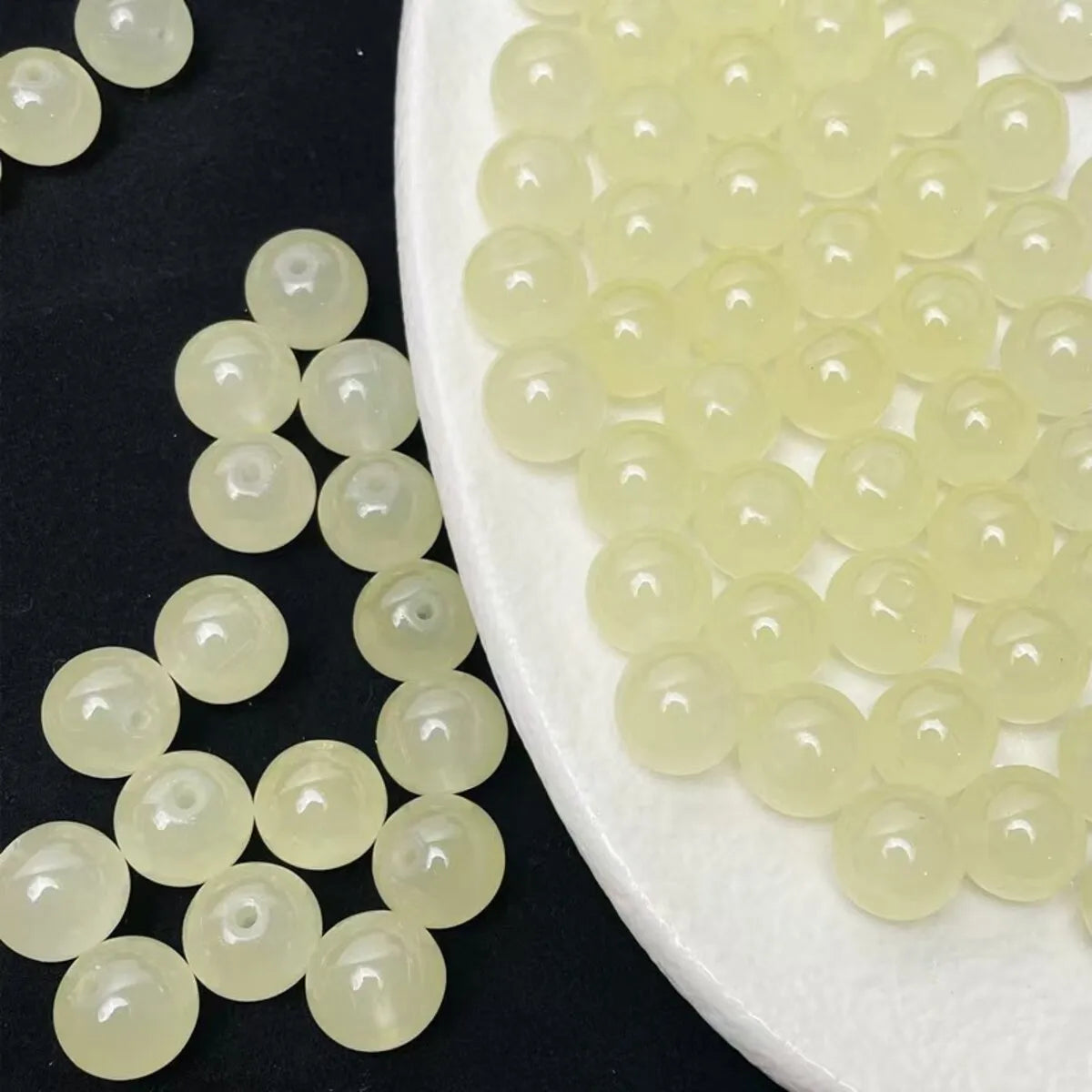 A pile of pale yellow and clear glass round beads for jewelry making