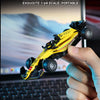 A yellow and black 1:64 scale formula racing car is held by a hand, with another model visible in the background.