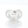 A clear storage case for a baby pacifier featuring a crown design and the name Sofia engraved on the cap.