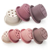 A set of silicone stacking cups for toddlers in pink and mauve colors.