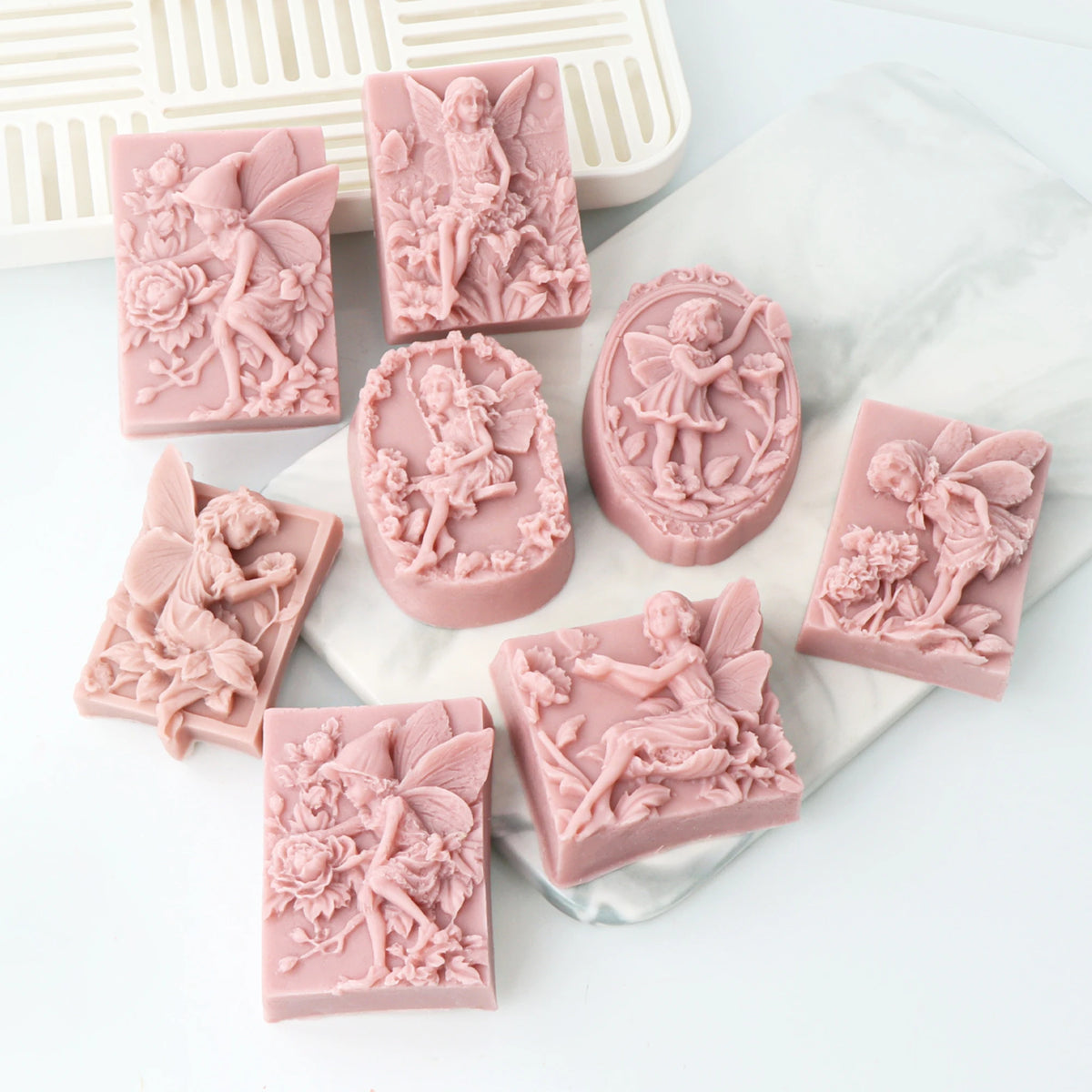 Pink silicone soap molds featuring 3D flower fairy, angel girl, rose, and butterfly designs.