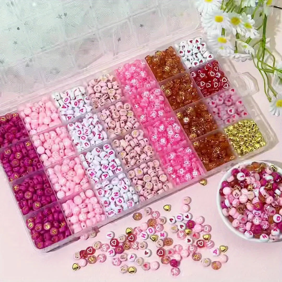 A variety of pink, red, and white acrylic beads with gold accents are displayed in a clear plastic box.