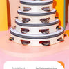 A stack of white log/mahogany tambourines with metal jingles displayed against a colorful background.