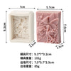 A pink silicone soap mold featuring a 3D design of a flower, rose, and butterfly.