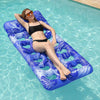 A woman relaxing on a blue inflatable pool float with a headrest in clear water.