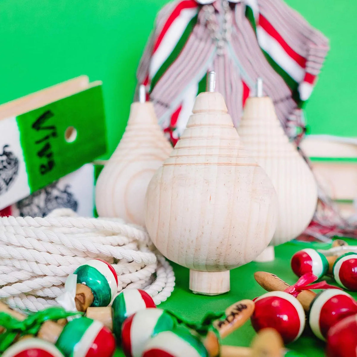 Three unfinished wooden spinning tops with steel points for a paint your own craft toy set