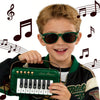 A smiling boy holds a green mini piano keyboard for kids.