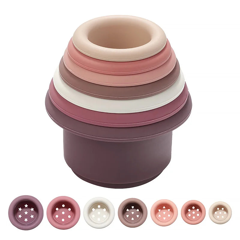 A stack of five silicone cups in shades of pink and purple, showing various sizes.