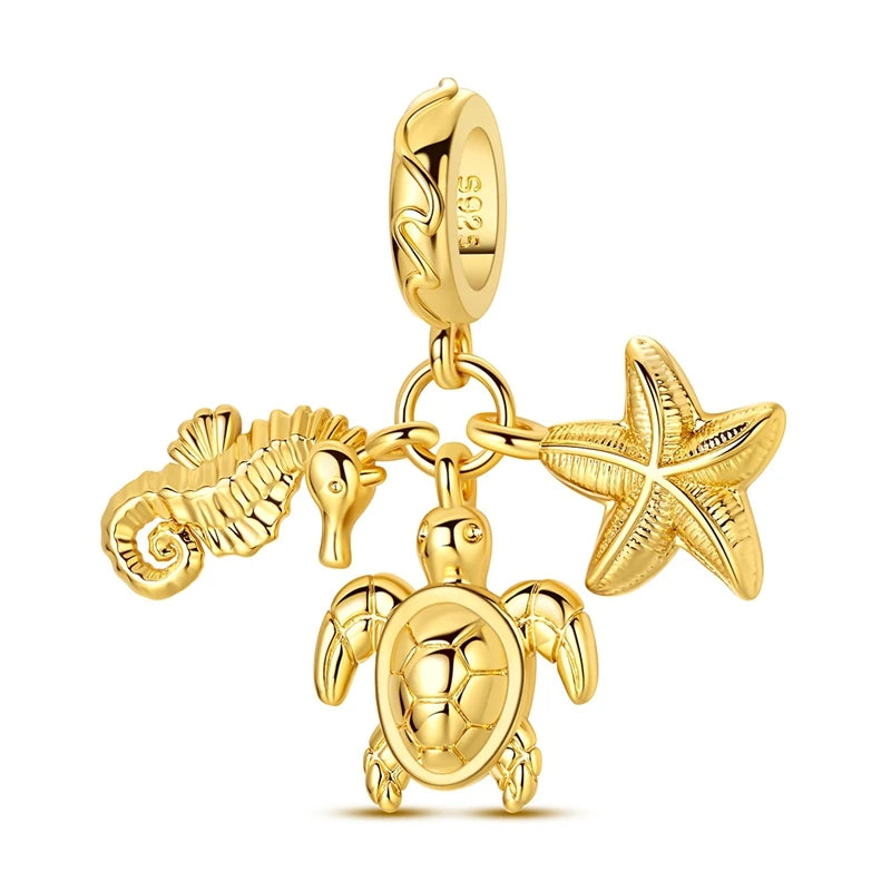 Gold-toned charm pendant set featuring a starfish, sea turtle, and whale shark.