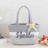 A gray braided cotton tote bag with the word Hello embroidered on the front and a yellow flower decoration.