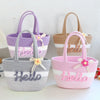 Three braided cotton tote bags in purple, beige, and pink with floral accents.