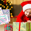 A toddler in a red shirt is looking at a colorful potty chart and a wrapped gift.