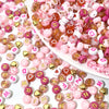 Assortment of pink, red, and white acrylic beads with gold accents for jewelry making