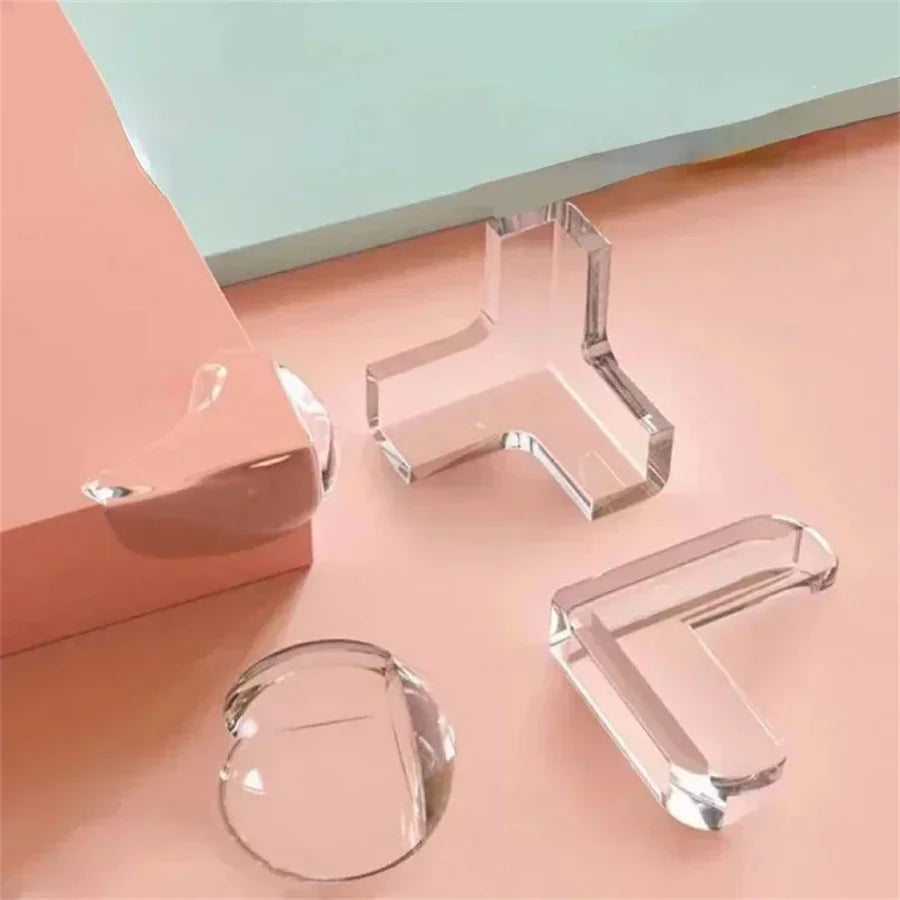 Klare Silikon-Eckschutzkappen für Babysicherheit, präsentiert auf einer rosa Oberfläche.