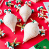 Three unfinished wooden spinning tops with steel points are displayed on a red surface for a paint your own craft toy project