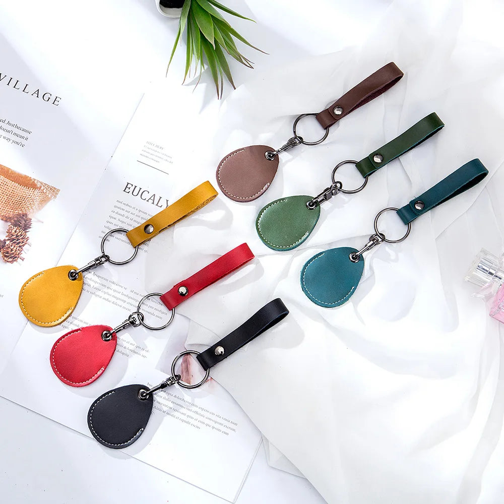 A collection of vintage cowhide leather key wallets and card holders in various earthy tones like brown, olive green, yellow,