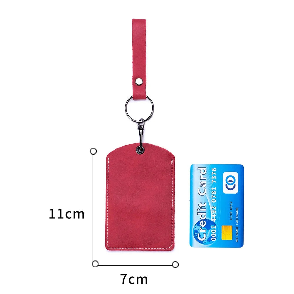A red leather card holder attached to a keyring and a leather strap.