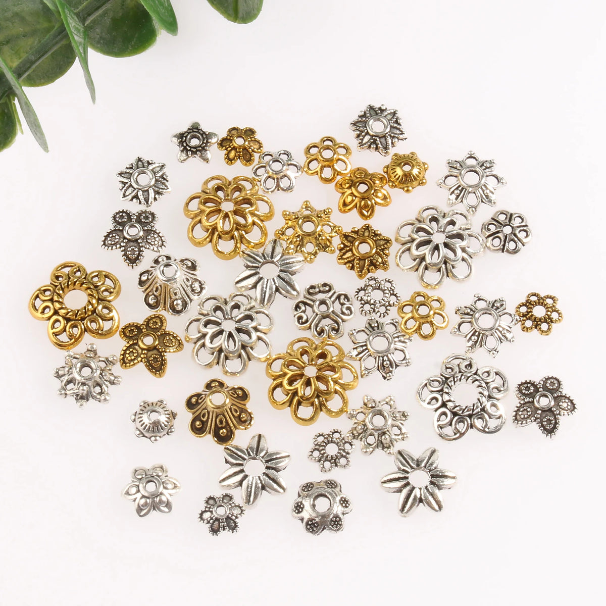 A collection of silver and gold Tibetan style hollow flower bead caps for jewelry making.