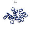 A pile of blue metal open jump rings for DIY jewelry making.
