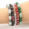 A bracelet made of various colored crystal rhinestone spacer beads, including green, red, black, and clear stones.
